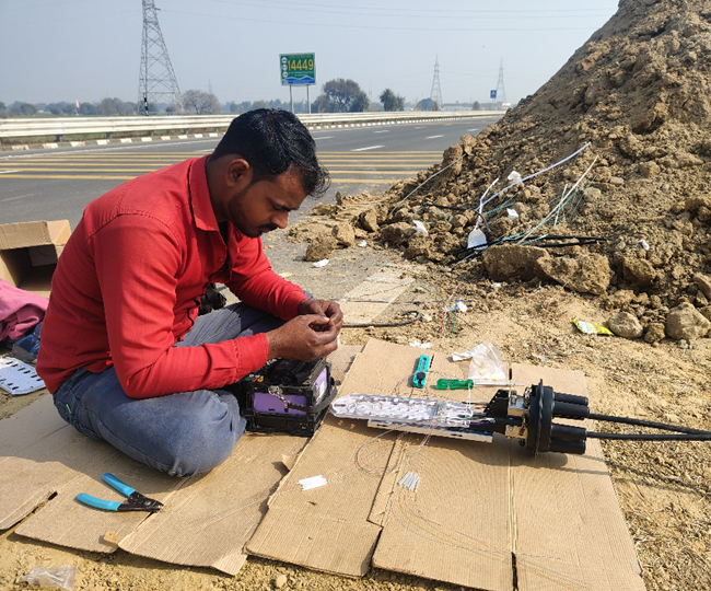 गंगा एक्सप्रेस वे पर सीसीटीवी की लाइन जोड़ने का काम करते कर्मचारी। जागरण